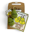 Two green handmade crochet pear keychains with cute faces, illustrated Perfect Pear card, and kraft gift bag