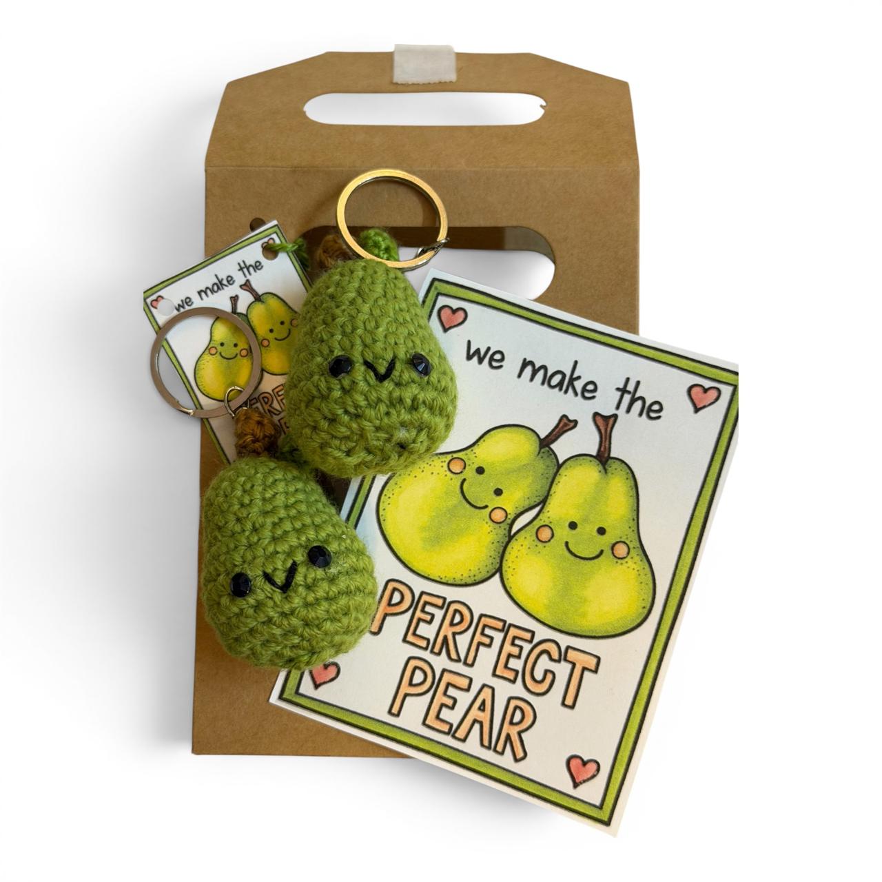 Two green handmade crochet pear keychains with cute faces, illustrated Perfect Pear card, and kraft gift bag